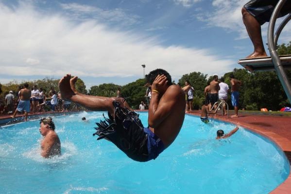 A person performing a manu into a swimming pool