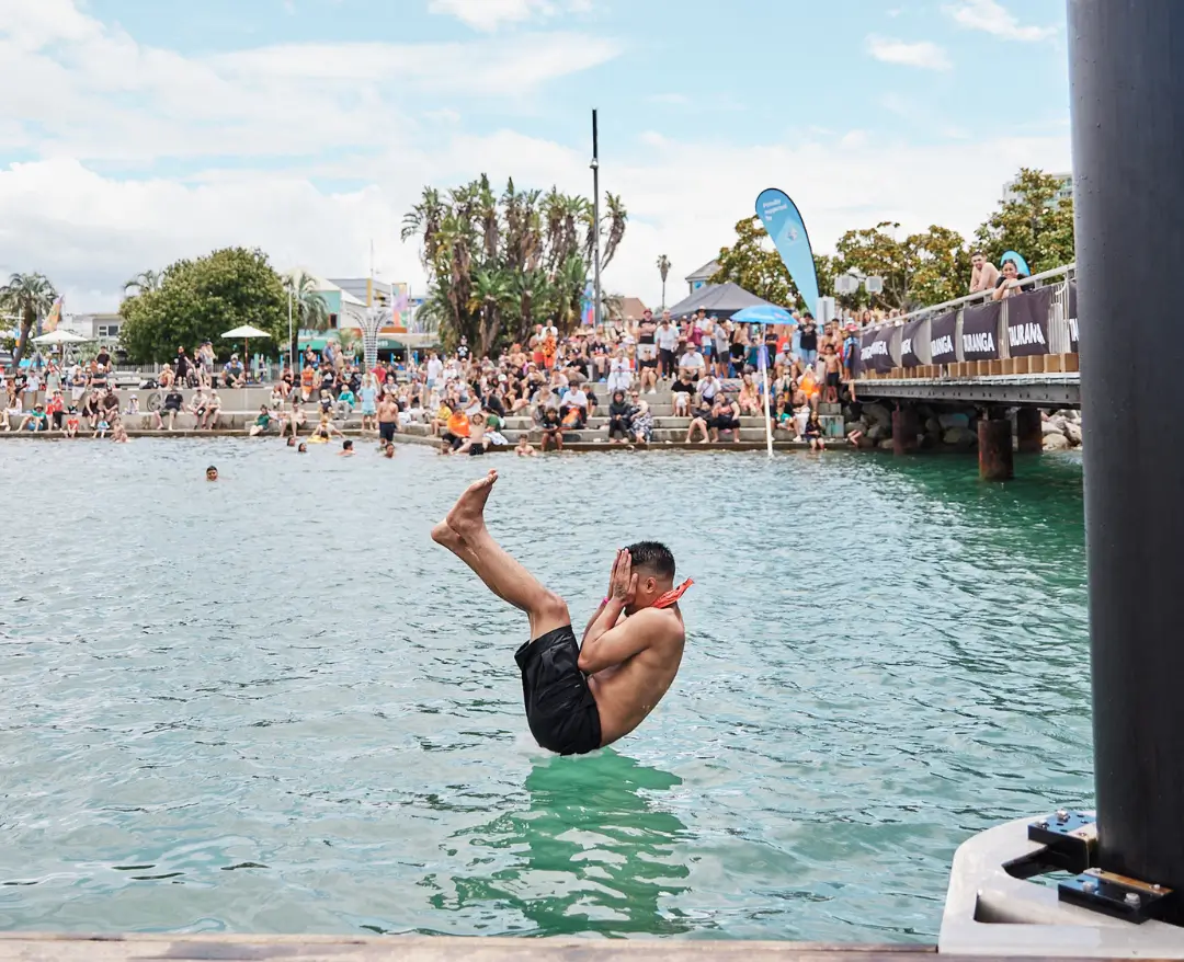 A person performing a manu, about to splash into the water