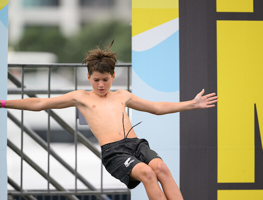 A contestant jumping off the Manu World Champs platform, mid-manu